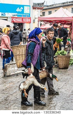 YUANYANG, CHINA - FEBRUARY 28,2016: Chinese Hani farmers sell their goods on the market,The Hani or Ho people are an ethnic group of Southeast Asia