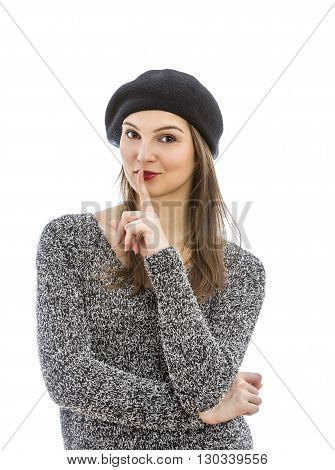 Portrait of a young woman with a silence gesture isolated against a white background.