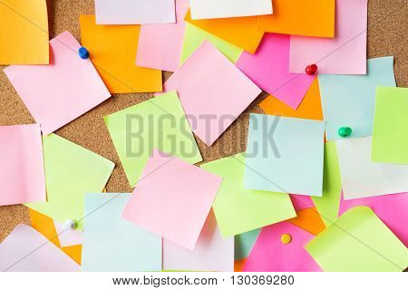 business, information, memo, management and education concept - close up of blank paper stickers on cork board