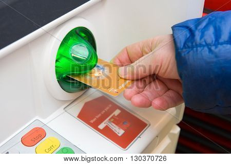 ENSCHEDE NETHERLANDS - MARCH 31 2016: A man is entering his bank card into an ATM machine