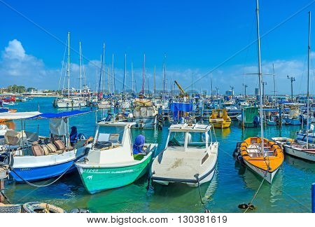 ACRE ISRAEL - FEBRUARY 20 2016: The colorful fishing boats rocking on the waves in marina of Akko on February 20 in Acre.