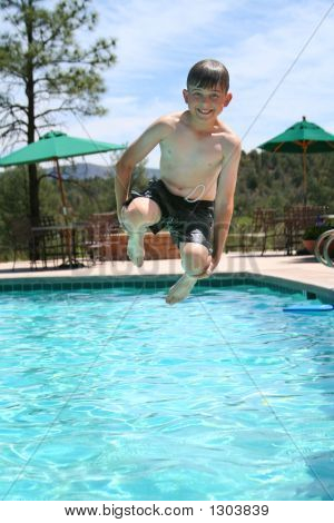 Niño sonriendo y saltando en una piscina