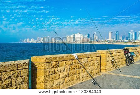 The fishing rods on the city promenade with the view on city of Tel Aviv on background Israel.