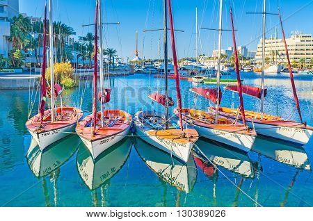 EILAT ISRAEL - FEBRUARY 23 2016: The sailing yachts in bright sun beams with the clear reflection in water on February 23 in Eilat.