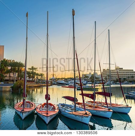 EILAT ISRAEL - FEBRUARY 23 2016: The small sailing yachts in Lagoona in bright sunset lights on February 23 in Eilat.