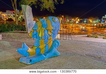 EILAT ISRAEL - FEBRUARY 23 2016: The golden symbols of luck are painted on the sculpture of the fish in front of Eilat Museum on February 23 in Eilat.