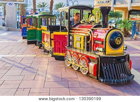 EILAT ISRAEL - FEBRUARY 23 2016: The colorful tourist train offers the pleasure rides along the promenade on February 23 in Eilat.