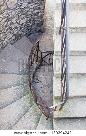 The circular staircase in the tower with iron railing. View from above.