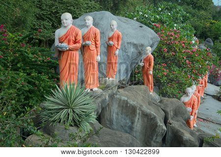 DAMBULLA, SRI LANKA - MARCH 14, 2015: Procession of Buddhist monks with offerings. The sculptural composition in the Golden temple. Dambulla. The landmark of Dambulla, Sri Lanka