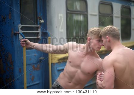 Muscular Guys Near Railway Train