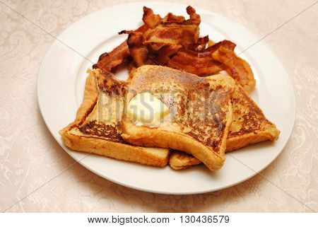 French Toast with Butter Served with a Side of Crispy Bacon