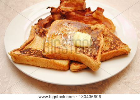 French Toast with Butter Served with a Side of Crispy Bacon