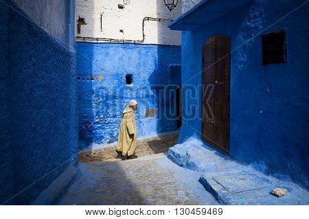 Chefchaouen Morocco - April 10 2016: An old man walking in a street of the town of Chefchaouen in Morocco.
