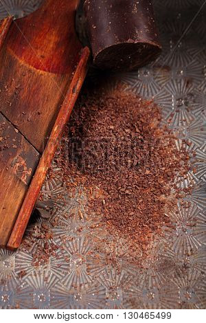 grated 100% dark chocolate flakes on vintage  wooden grate,   shallow DOF