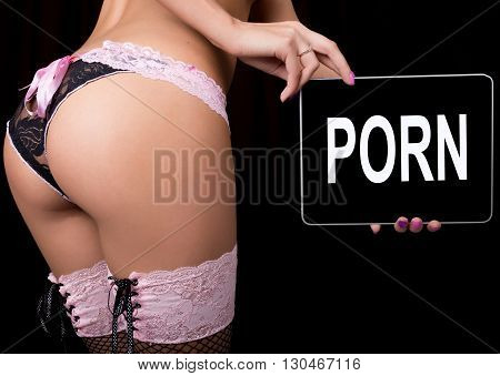 technology, internet and networking - close-up ass of girl in lacy lingerie, holding a tablet pc with porno sign. Adult content.