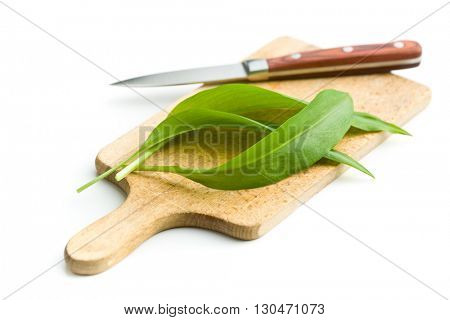 Fresh ramsons leaves and cutting board with knife. Wild garlic leaves isolated on white background.
