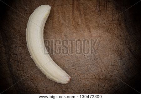 unskin banana on a wooden chop board