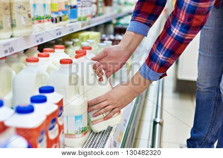 The woman shopping milk in grocery store