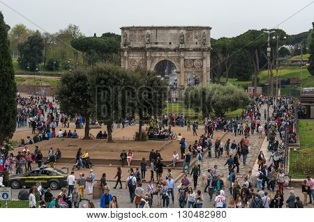 ROME ITALY - APRIL 7: Tourists visiting Arco de Constantino (Arch of Constantine) and Colosseum. The arch was erected by the Roman Senate to commemorate Constantine victory over Maxentius