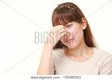 portrait of young woman suffers from Asthenopia on white background