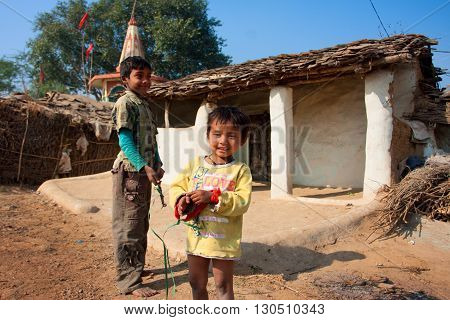 CHITRAKOOT, INDIA - DEC 29, 2012: Unidentified children play outdoor near the mud village houses on December 29, 2012 in Chitrakoott Madhya Pradesh India. Madhya Pradesh state has 105592 primary schools