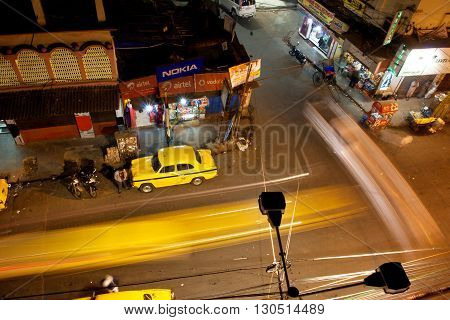 KOLKATA, INDIA - JAN 13, 2013: Night city with fast moving cars and Ambassador taxi cabs on January 13, 2013 in India. Hindustan Ambassador is a car manufact. by Hindustan Motors of India since 1958