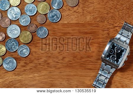 Men's wrist watch and metal coins as in time is money concept