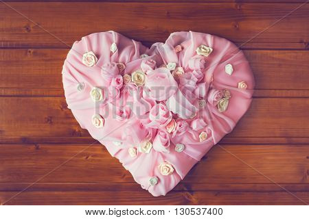 Pink Textile chiffon Heart with roses and other flowers on a wooden background.