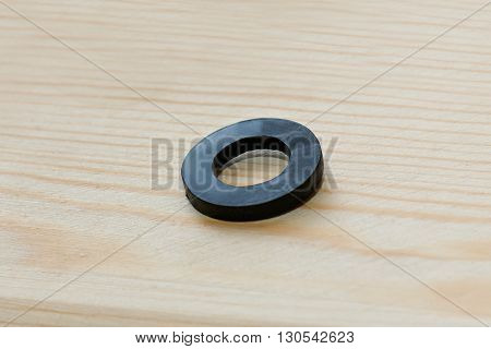 A single rubber spacer on a simple wooden background