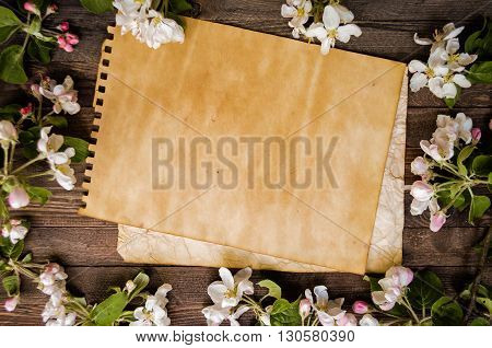 Vintage craft paper mock up on rustic wood background with natural decorations spring white blossom. Blank template, art letters, background space for text. Natural border background vintage mock up.