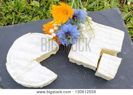 a normandie French cheese on a plate with flowers
