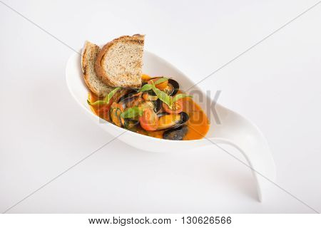 Fresh yellow italian mussels soup with croutons