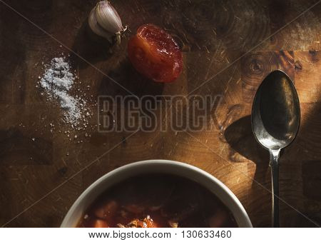 lunch Russian cabbage soup, garlic, salt and tomato on a wooden table