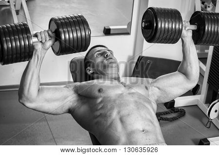Strong man. Muscle training in the gym. Training in the gym.