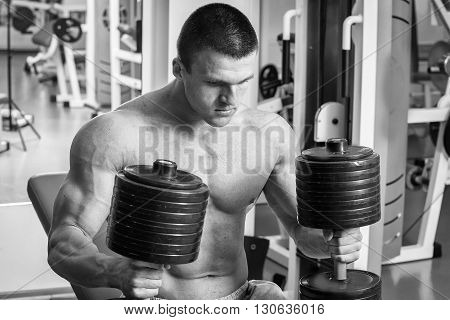 Strong man. Muscle training in the gym. Training in the gym.