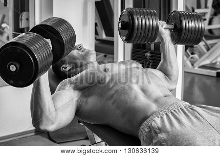 Strong man. Muscle training in the gym. Training in the gym.