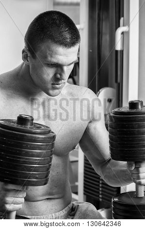 Strong man. Muscle training in the gym. Training in the gym.