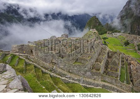View of the Lost Incan City of Machu Picchu near Cusco.Low clouds cover mountains.Cusco RegionSacred Valley Peru