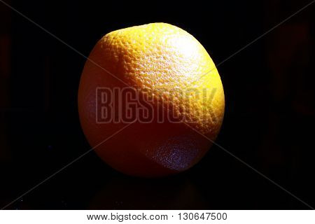Orange fruit isolated on black background, dark