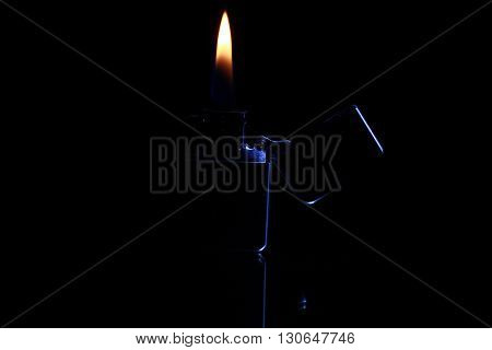 black gasoline lighter with flame on dark background