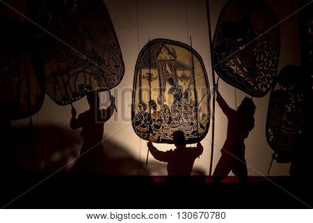 RATCHABURI THAILAND - APRIL 14 2015: The Cowskin shows a man holding a stencil pattern. Moving Cowskin the light to shadow play. The musical atmosphere and read a poem composed. In a traditional culture. There are performances every year Thailand in SONGK