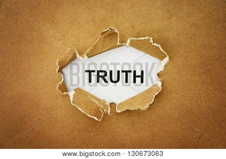 the word "truth" in the hole of brown paper