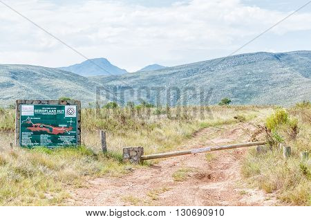 BAVIAANSKLOOF SOUTH AFRICA - MARCH 6 2016: Information board and boom for the Bergplaas Hut in the Baviaanskloof (baboon valley). The board indicates distances and travel times from this point