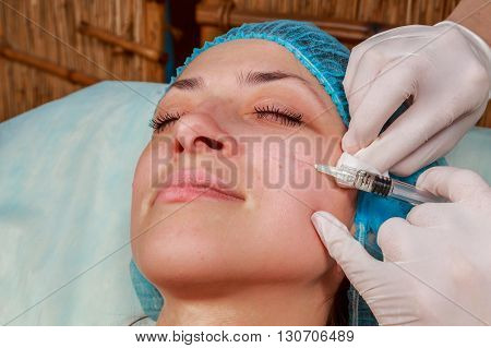 Cosmetic injection in the spa salon. Beautician makes injection into the patient's face. Beauty injections mesotherapy revitalization cosmetic medicine injection - the concept of rejuvenation.