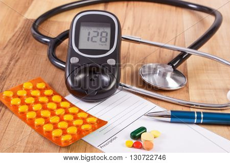 Medical pills tablets or supplements for therapy prescription glucose meter and stethoscope on desk in doctor office concept of diabetes treatment and health care