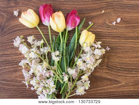 Beautiful Flowers Tulips And Chestnuts On A Wooden Table