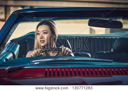 Smiling attractive girl sitting in vintage car South Australia