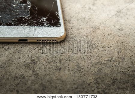Close up of broken mobile phone or tablet droped on cement floor with copy space High contrast