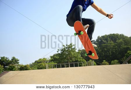 young woman skateboarder practice ollie at skatepark
