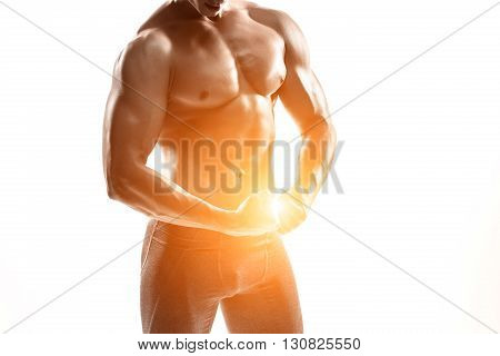 Close-up strong bodybuilder man posing with perfect abs, houlders, biceps, triceps and chest. Isolated on white background Whith solar flare